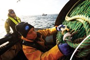 Fishermen arranging nets on board