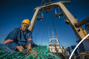 Fisherman repairing net south african Hake fishery